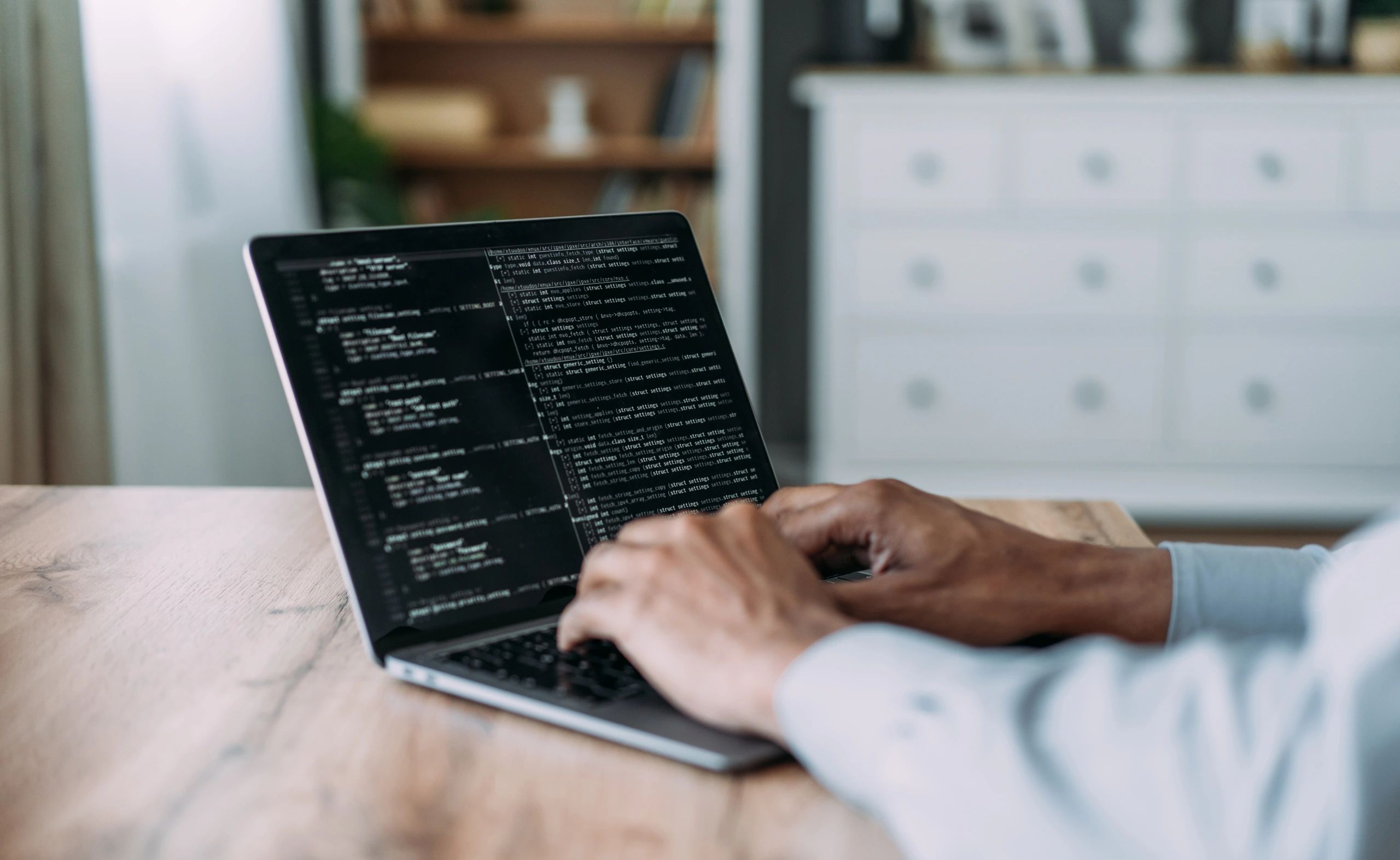 Software engineer working on a laptop with code on screen